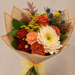 Bouquet of mixed flowers wrapped in brown paper with a yellow ribbon