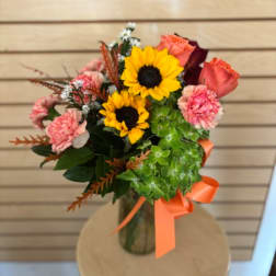 Bouquet with sunflowers, pink roses, and carnations in a vase