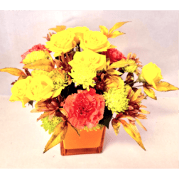 Yellow and coral flowers arranged in an orange square vase
