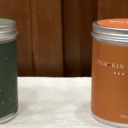 Two colored metal tins with lids on a white surface