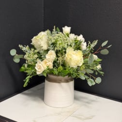 White rose bouquet in a cream ceramic vase