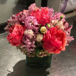 Pink and red mixed bouquet in a square glass vase