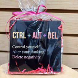 Gift bag with a black card reading "CTRL + ALT + DEL" and pink ribbon