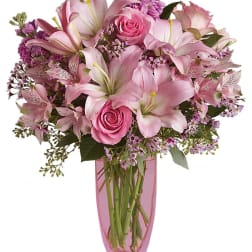 Pink lilies and roses arranged in a pink vase