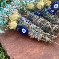 Bundles of dried flowers tied with blue cord and evil eye charms