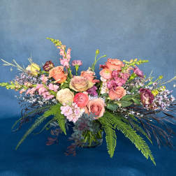 Mixed bouquet of pink and peach flowers in a glass vase