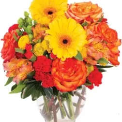 Bouquet of yellow gerbera daisies and orange roses in a clear glass vase