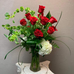 Red roses and white hydrangeas in a clear glass vase