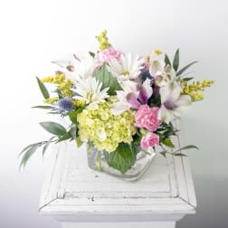 Mixed bouquet in a clear glass vase with white daisies and pink carnations