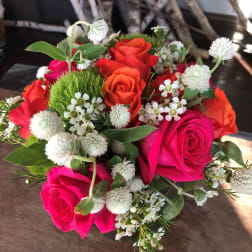Bouquet of hot pink and orange roses with white filler flowers