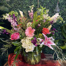 Mixed bouquet in a glass vase with pink, red, white, and purple flowers