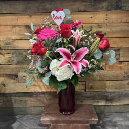 Bouquet of red roses, pink lilies, and white hydrangea in a vase