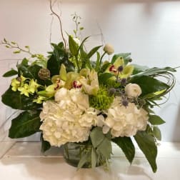 White and green floral arrangement in a glass vase