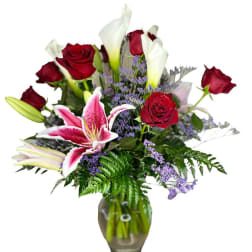 Bouquet of red roses and pink lilies in a glass vase