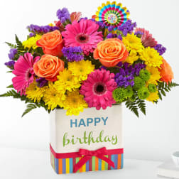 Bright mixed bouquet in a birthday gift box with a colorful topper.