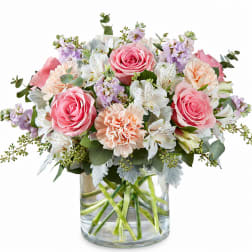 Pink roses and peach carnations in a clear glass vase