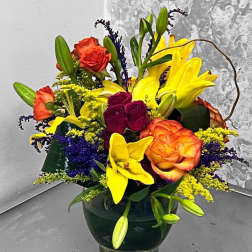 Colorful bouquet of roses and lilies in a glass vase