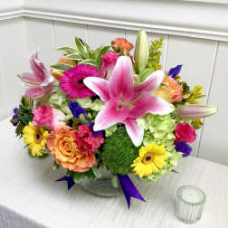 Mixed bouquet in a clear glass vase with pink lilies, roses, and gerbera daisies