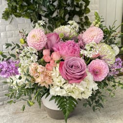 Pink and white mixed flower arrangement in a round vase