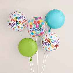 Cluster of colorful birthday balloons with polka dots and "Happy Birthday" text