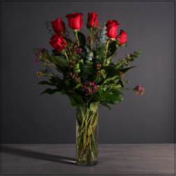 Red roses arranged in a clear glass vase