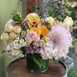 Mixed pastel flower arrangement in a dark green vase