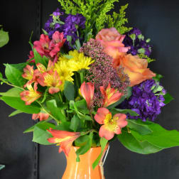 Colorful mixed bouquet in an orange vase