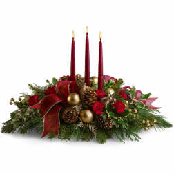 Low Christmas centerpiece with red carnations, gold accents and three red taper candles.