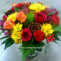 Mixed bouquet of roses and yellow daisies in a glass vase
