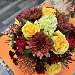Bouquet of yellow roses, burgundy chrysanthemums, and pale green hydrangea