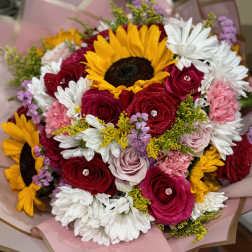 Bouquet of sunflowers, red roses, and white daisies wrapped in pink paper