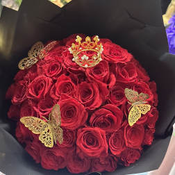 Bouquet of red roses wrapped in black paper with gold butterfly accents