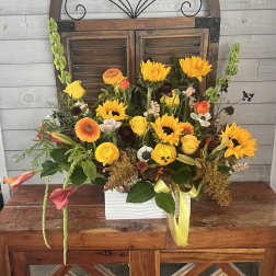Mixed bouquet in a white rectangular vase with yellow and orange flowers