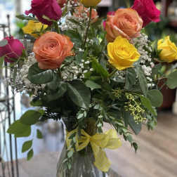 Mixed roses in a glass vase with baby's breath and greenery