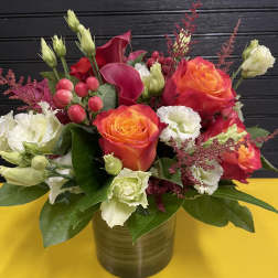Bouquet of orange roses and white lisianthus in a gold vase