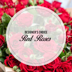 Bouquet of red roses with a circular label reading Designer's Choice Red Roses