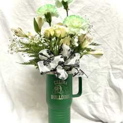 White and pale green flowers in a green travel tumbler with a bow