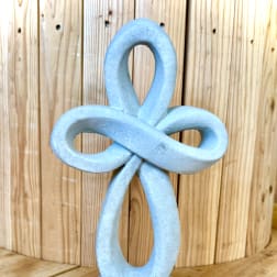 Blue decorative knot sculpture against a wooden background