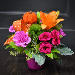 Bright mixed bouquet in a magenta pot with orange lilies and pink roses