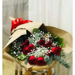 Bouquet of red roses with baby's breath wrapped in tan paper