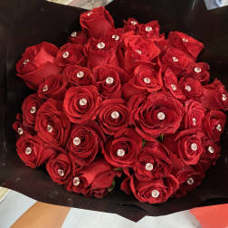 Bouquet of red roses with clear gem accents wrapped in black paper