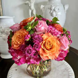 Mixed pink and orange roses in a clear glass vase