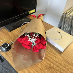 Bouquet of red roses with white baby's breath in brown paper wrap