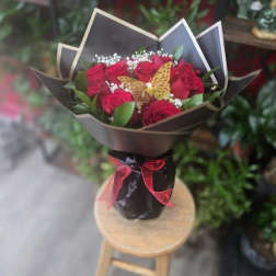 Bouquet of red roses with a butterfly decoration in black wrap