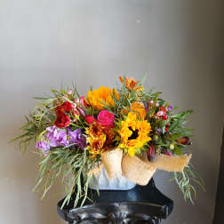 Colorful mixed bouquet in a vase with sunflowers, roses, and purple blooms