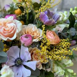 Bouquet of peach roses and purple anemones with yellow filler flowers