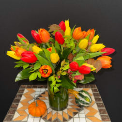 Bouquet of red, yellow, and orange tulips in a glass vase