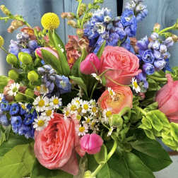 Bouquet of pink roses, blue flowers, and white daisies