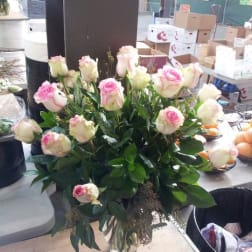 Pink and white roses arranged in a clear glass vase