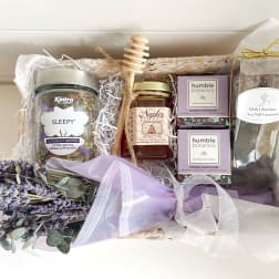 Gift basket with lavender flowers, tea, honey, bath bombs, and chocolates